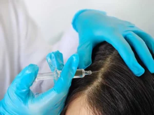 a person injecting hair with a syringe