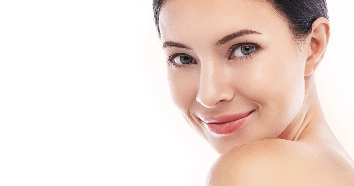 Young woman with dark hair, clear skin, and a friendly smile looking over her shoulder for Biostimulators in Tampa, FL.